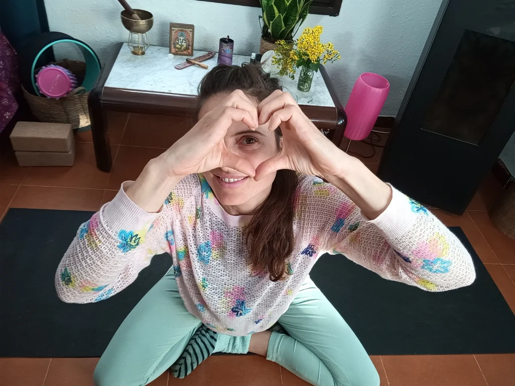 chica haciendo un corazón con sus manos y mira a través de este.